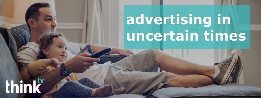 Dad and daughter watching TV together on the couch with text overlay: "advertising in uncertain times."
